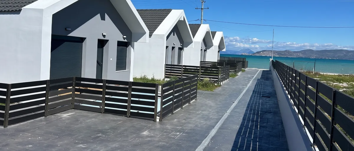 The lane lined with the five villas of Cape Poseidon leading towards the sea